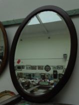 Oval bevelled mirror in mahogany frame
