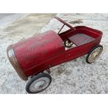 A pedal car requiring some restoration.