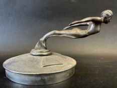 A Desmo car mascot in the form of a diving nude female, display base mounted, approx. 7 1/4" wide.