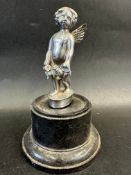 A car accessory mascot in the form of a cherub, display base mounted, approx 6" high overall.