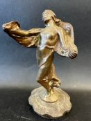 A car mascot in the form of a lady swathed in cloth, approx. 8" tall, radiator cap mounted.
