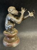A car accessory mascot in the form of a crouching naughty monkey, approx. 4 1/2" high.