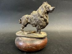 A well-detailed car accessory mascot in the form of a standing poodle, stamped to base: Finnigans,