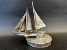 An unusual car accessory mascot in the form of boat with three sails, display base mounted,