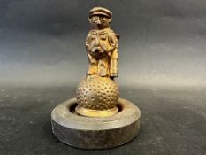 A car accessory mascot in the form of a golfer balanced on a golf ball, approx. 4" high.