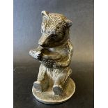 A car mascot in the form of a seated bear holding a pot of honey, no markings to base, possibly