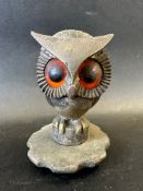 A car mascot depicting an owl perched, with large orange and black glass eyes, possibly French,