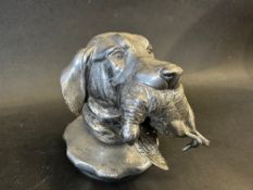 A good quality car accessory mascot in the form of a dog's head with game in its mouth, stamped '