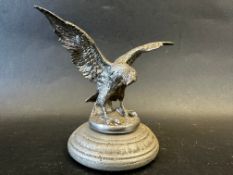 A car accessory mascot in the form of a bird of prey with outstretched wings, display base