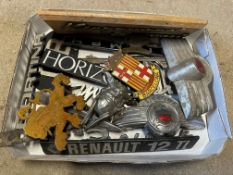 A tray of assorted car insignia and badges.