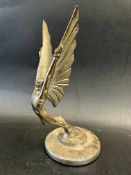 A car accessory mascot in the form of a stylised winged male figure, mounted on a radiator cap,