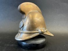 A brass car mascot in the form of a fireman's helmet, metal display base mounted, approx. 4" tall