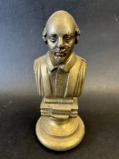 A brass car mascot in the form of a bust of William Shakespeare upon books, display base mounted,