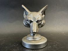 A car accessory mascot in the form of fox's head, display base mounted, approx. 3 1/2" high overall.