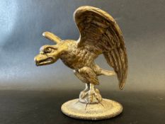A car mascot in the form of an eagle, several stamped markings around the display base including