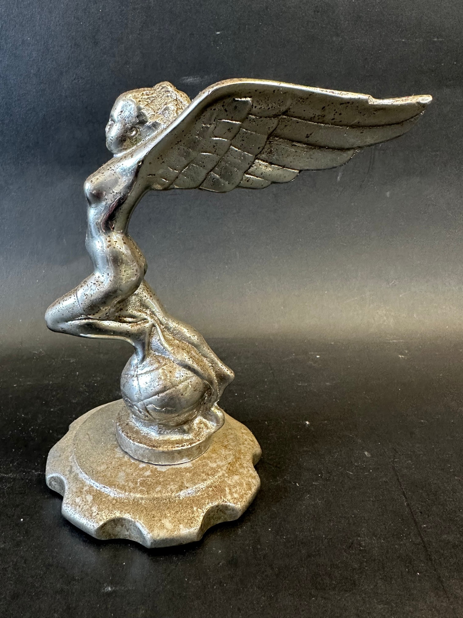 A car mascot in the form of a winged lady on top of a globe, possibly for the Triumph Gloria,