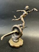 A car accessory mascot in the form of a nude female on a winged wheel, indistinctly stamped to base,