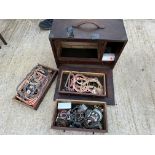 A wooden chest containing assorted gaskets and various small parts.