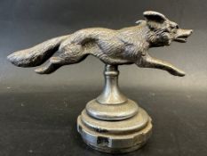A well-detailed car accessory mascot in the form of a running fox, mounted on a radiator cap,