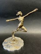 A car accessory mascot in the form of a female nude in yogic pose, beaing registration number,