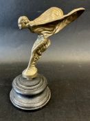 A Rolls-Royce Spirit of Ecstasy car mascot, wooden display base mounted, approx. 6" tall overall.