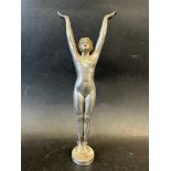An elegant car mascot in the form of a lady/adolescent with her arms lifted and palms open,