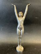 An elegant car mascot in the form of a lady/adolescent with her arms lifted and palms open,