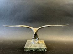 A car mascot depicting a bird in flight, marble base, stamped LL (Lejeune) to base approx. 3 1/2"