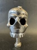 A car mascot depicting a human skull with snake to the top, approx. 4" tall.