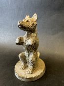 A car accessory mascot in the form of a dog begging, approx. 4" high.
