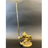 An unusual brass car mascot in the form of a troll running with a pole, approx. 10 3/4" tall.