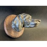 A car mascot in the form of a hound's head, wooden display base mounted, approx. 3 3/4" tall