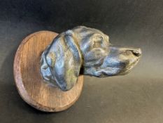 A car mascot in the form of a hound's head, wooden display base mounted, approx. 3 3/4" tall