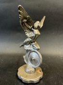 A car accessory mascot in the form of a nude, winged female knelt upon a wheel, approx. 6 3/4" high.
