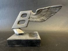 A Bentley winged B car mascot, leaning backwards, circa late 1930s, stamped with reg. no.