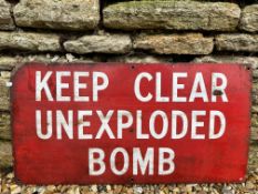 A rectangular warning enamel sign bearing the words 'Keep Clear Unexploded Bomb', 27 x 14".