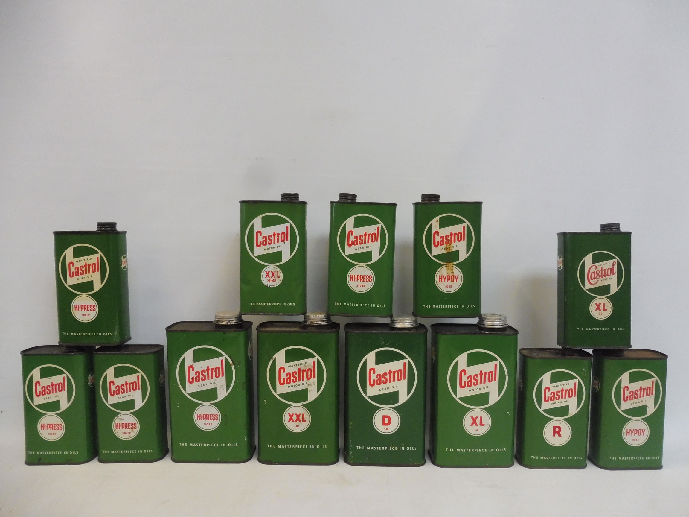 Four Castrol quart oil cans and nine pint similar.