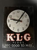 A Smiths Sectric tin fronted wall clock, with advertising for KLG Plugs, 10 1/2 x 14".