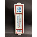 A small tin fronted thermometer bearing advertising for A.T.& T.