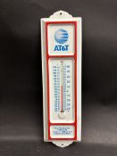 A small tin fronted thermometer bearing advertising for A.T.& T.