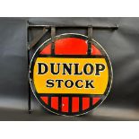 A Dunlop Stock circular double sided enamel sign in good condition, hanging on a wall bracket, the