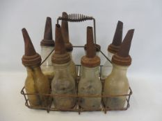 An American crate of eight glass oil bottles with tin spouts.