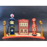 A Marx Toys tinplate garage forecourt comprising two petrol pumps flanking a central oil cabinet.