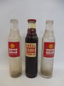 Three Shell X-100 glass oil bottles.