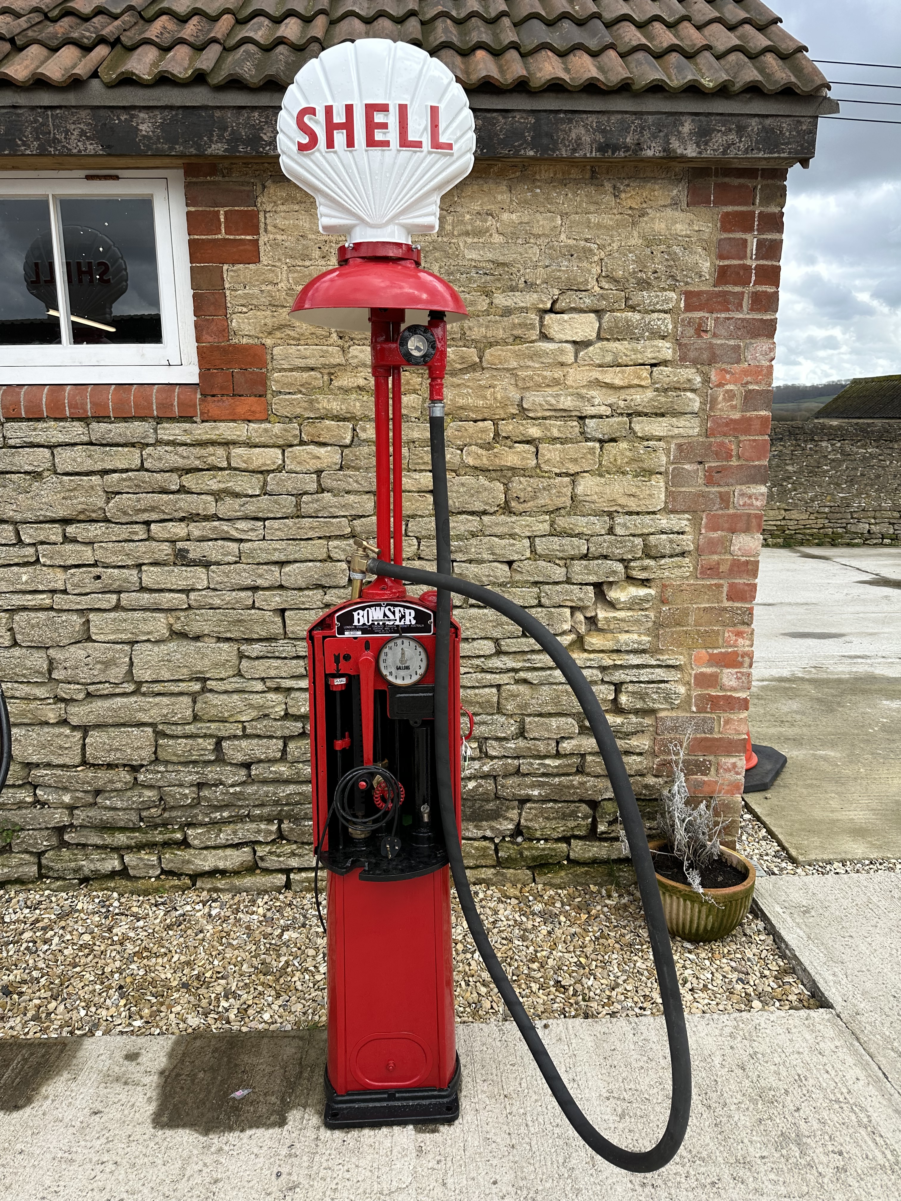 A Bowser hand-operated petrol pump, restored, with hose, nozzle and reproduction plastic petrol pump