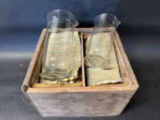 Two glass weight and measures vessels, in a wooden carry case.