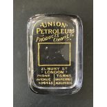 A Union Petroleum Products glass paperweight.