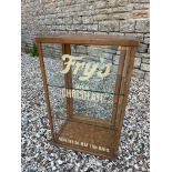A counter top display cabinet with rear opening door and two glass shelves, later lettering to the