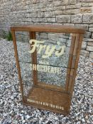 A counter top display cabinet with rear opening door and two glass shelves, later lettering to the