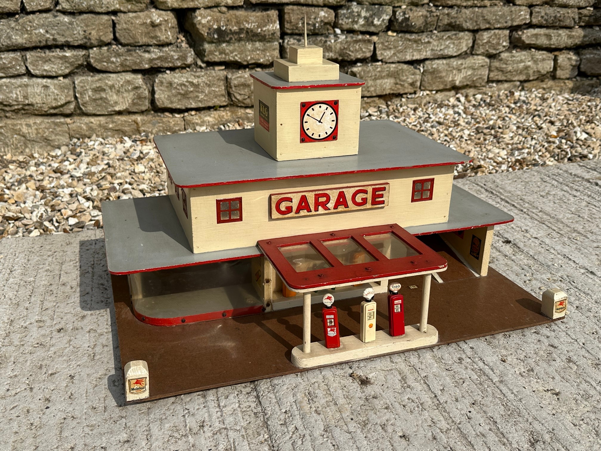 A well made model garage of Art Deco design, featuring two rows of die-cast petrol pumps.